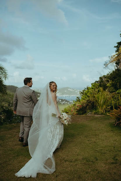 Happily married couple in the USVI with bride looking back smiling.