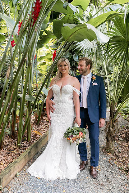 Beautiful wedding couple posing under the tropical foliage of the perfect USVI backdrop.